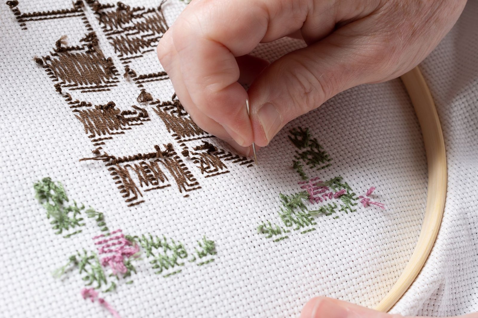 Close-up of hand embroidery thread being pulled through fabric with a needle