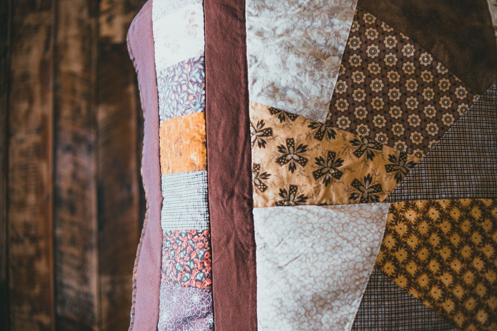Pieced flower quilt block showing floral fabric in earthy tones
