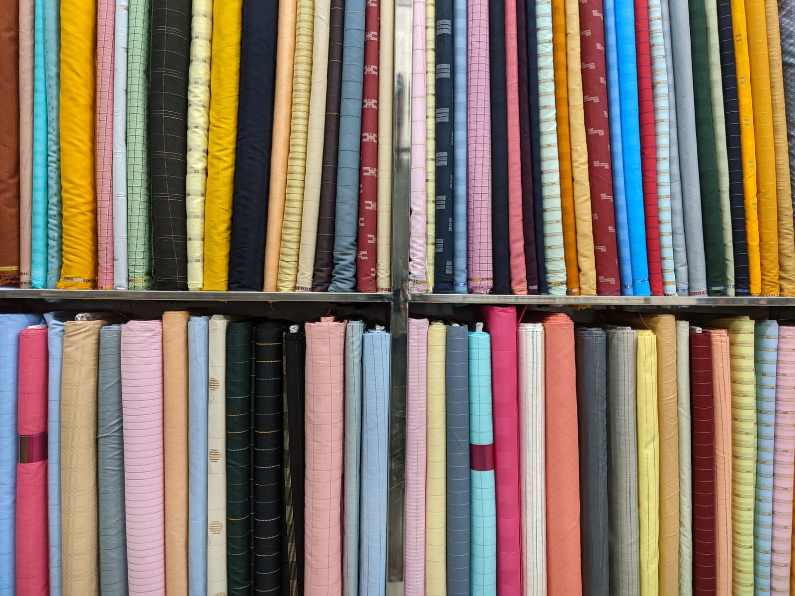 Shelves of folded fabric bolts in a variety of colors and finishes