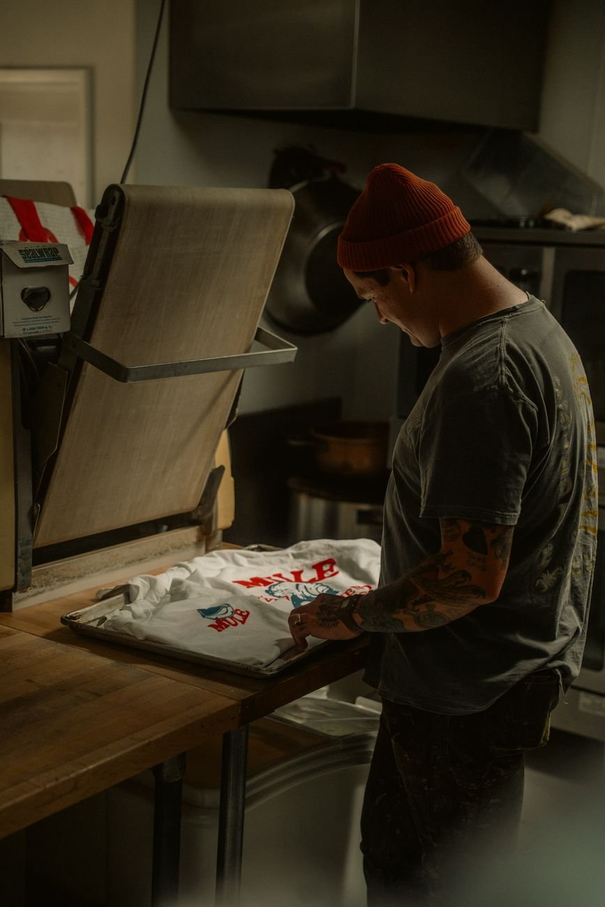 A person using a heat press to print a custom design onto a polyester t-shirt