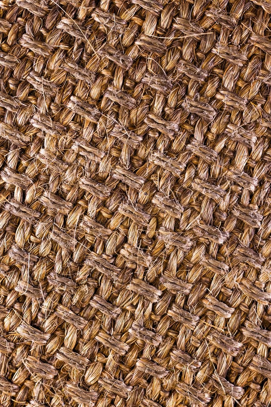Close-up of coarse, golden-brown jute fabric showing its natural woven texture