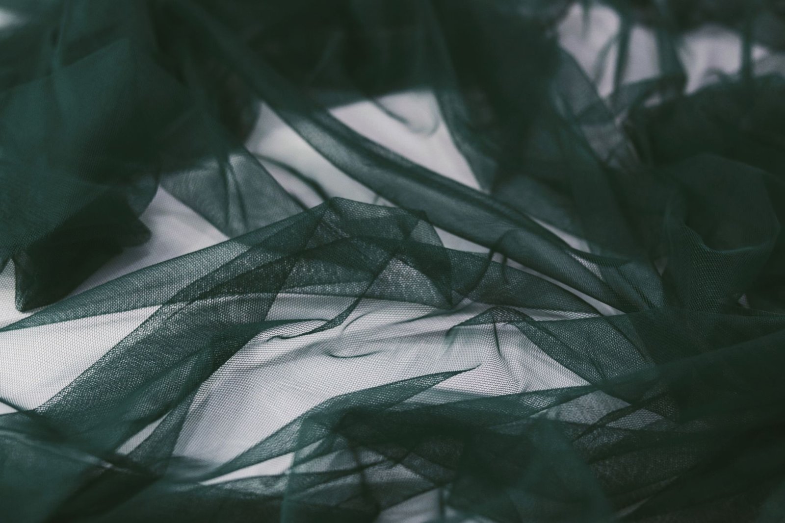 Dark green tulle netting fabric draped in soft folds
