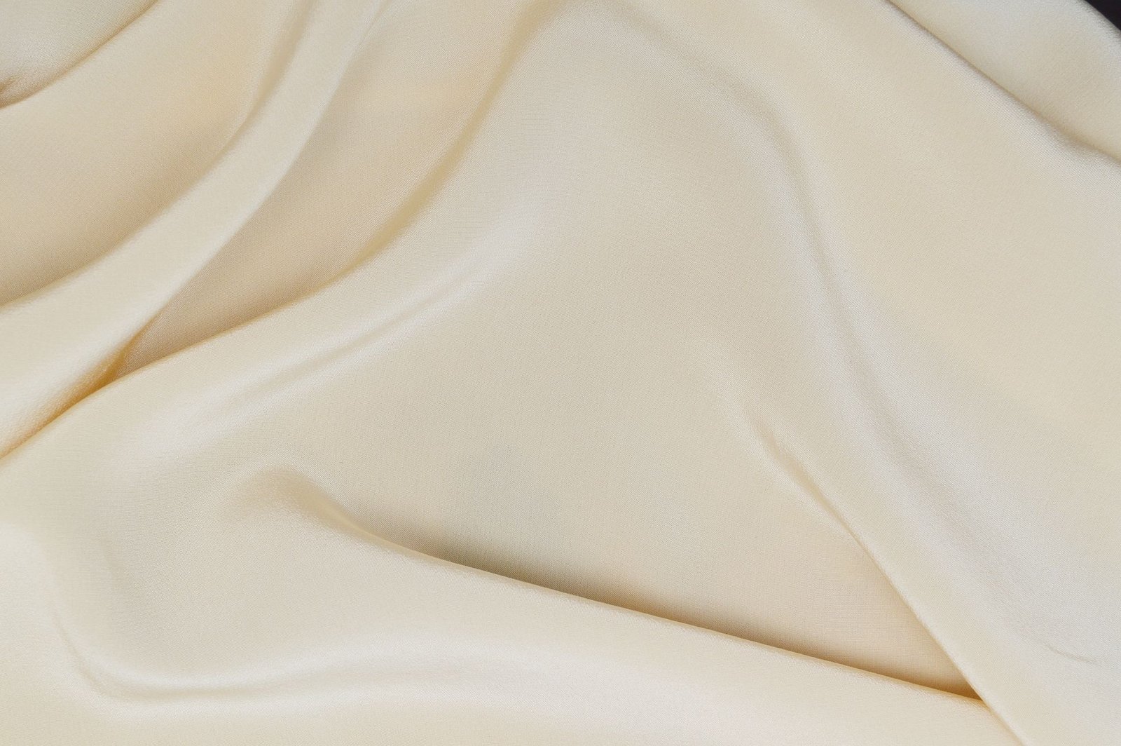 Delicate cream silk fabric showing its smooth texture and elegant drape