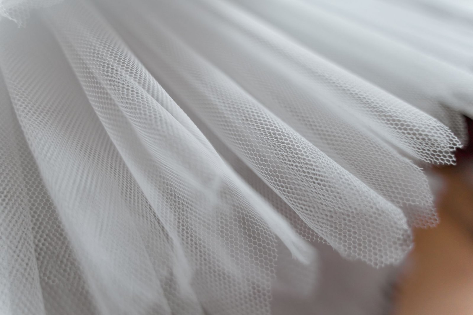 Close-up of grey polyester mesh fabric texture with small perforations