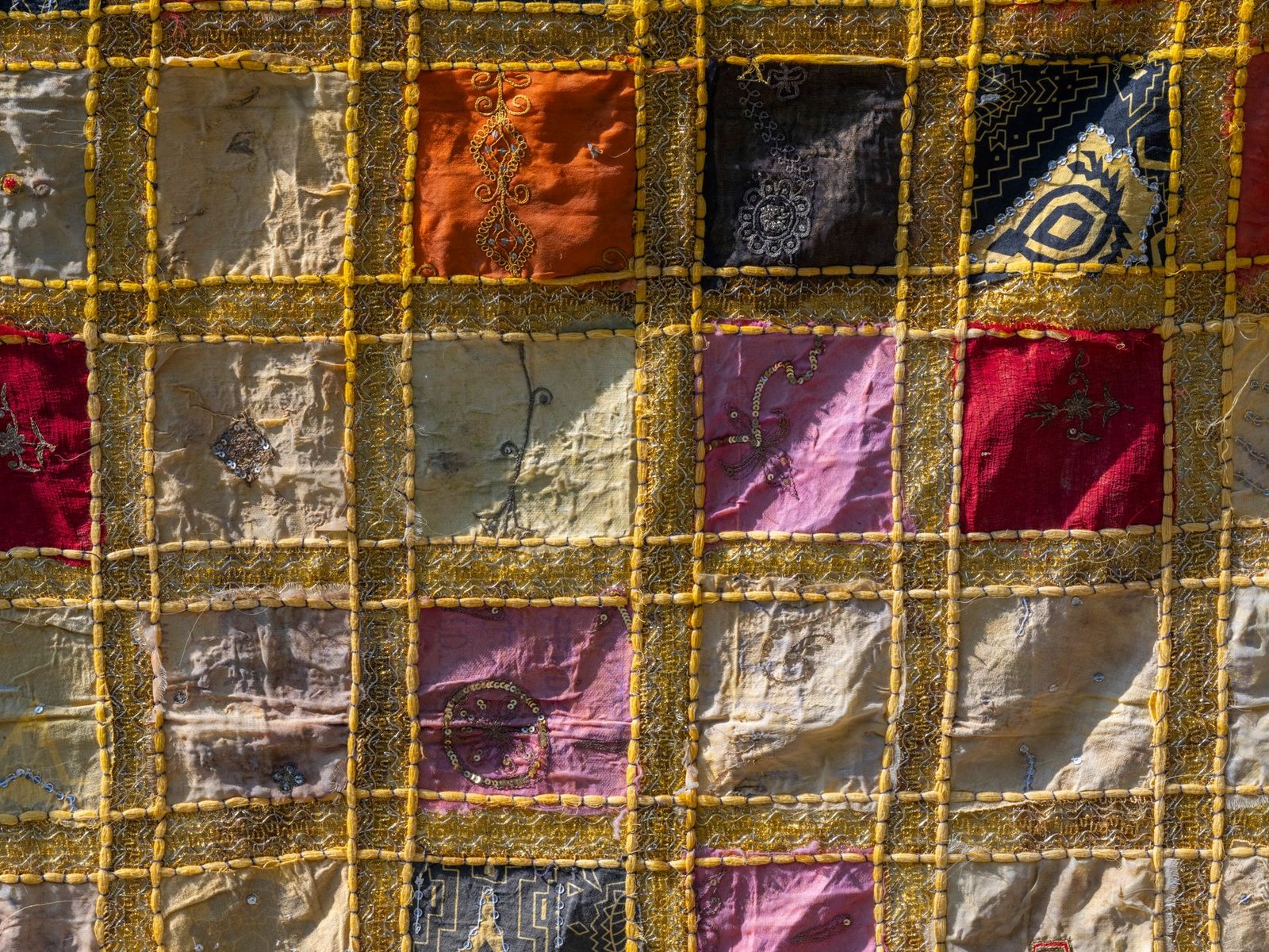 Dimensional stitched fabric quilt with a raised, biscuit-like surface