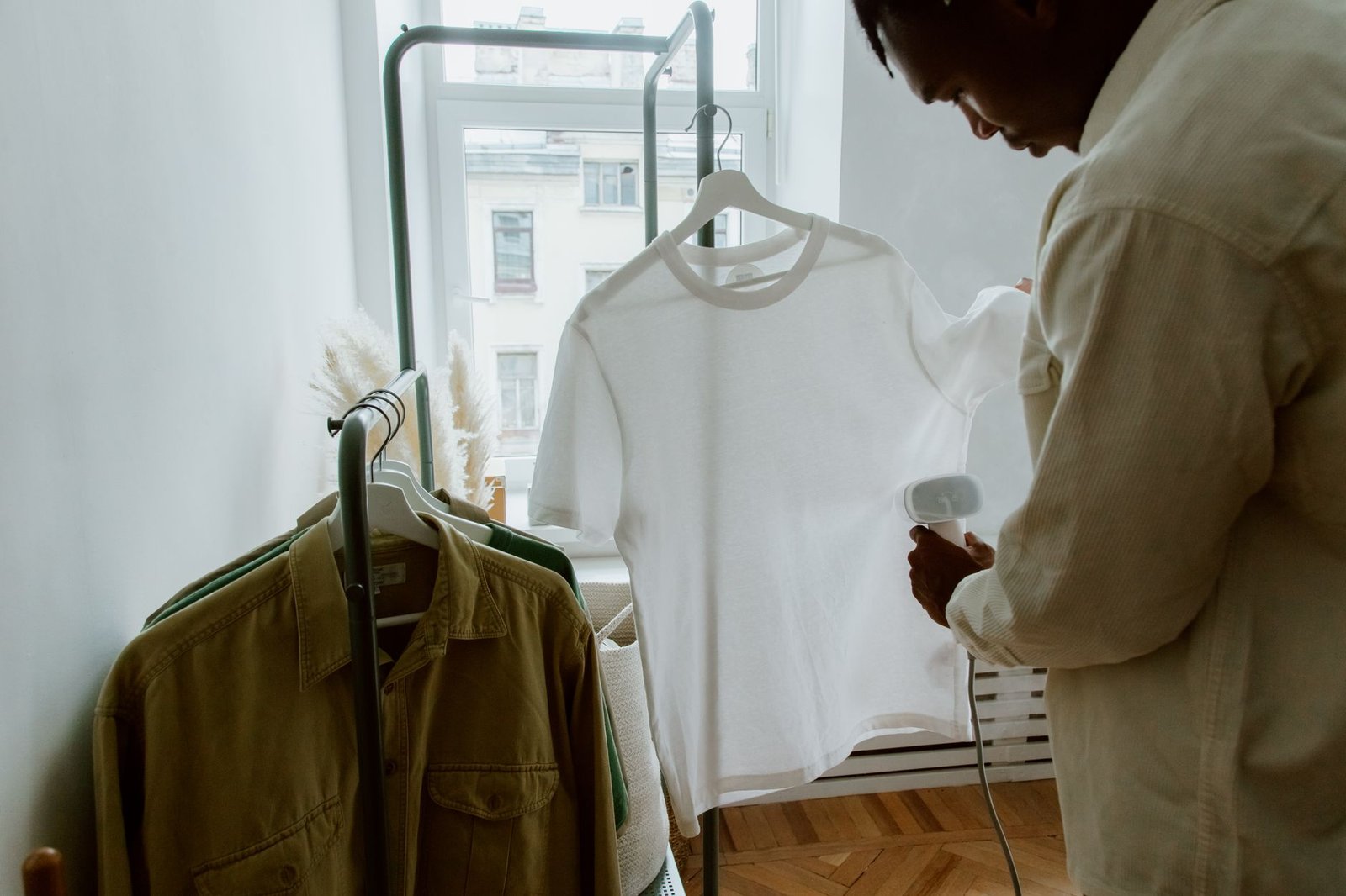 Handheld garment steamer being used on a white t-shirt