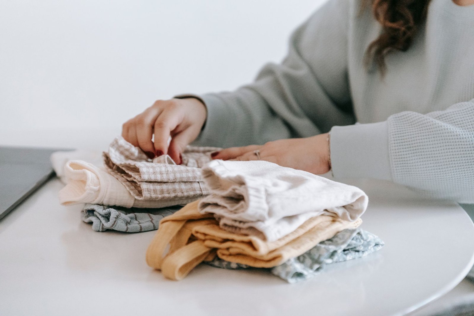 Hands folding a stack of soft fabric squares