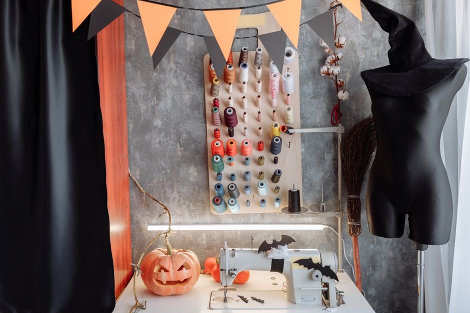 Halloween-themed sewing nook with thread spools, a jack-o-lantern, and a witch hat display