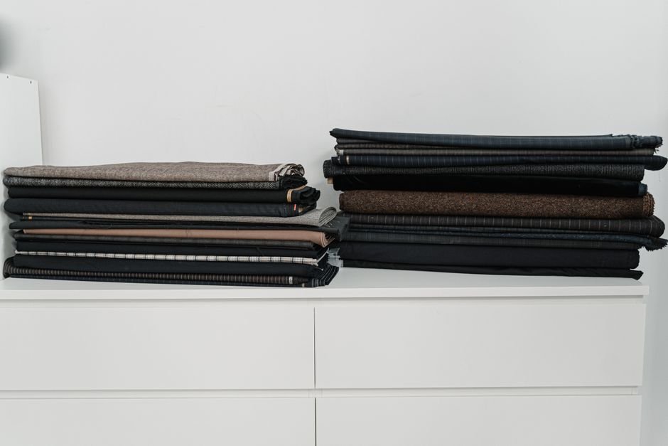 Stacks of folded dark t-shirt fabric ready for cutting