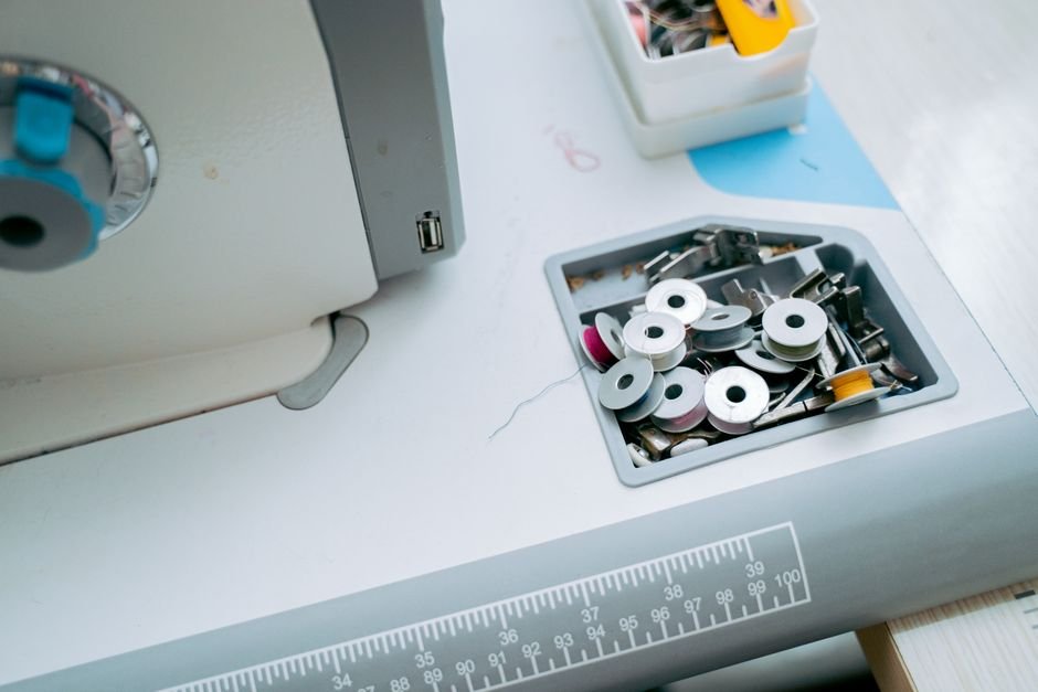 Sewing machine bobbin tray with thread spools on a workspace table