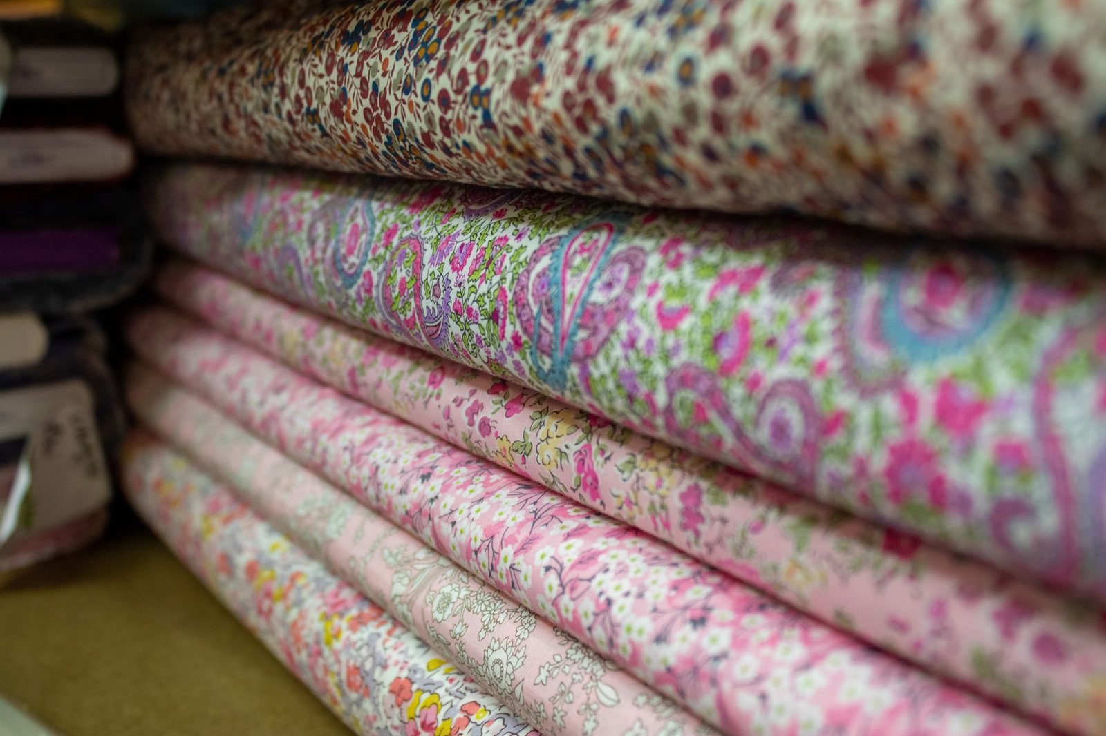 Rolled bolts of bold floral fabric in a coordinated palette