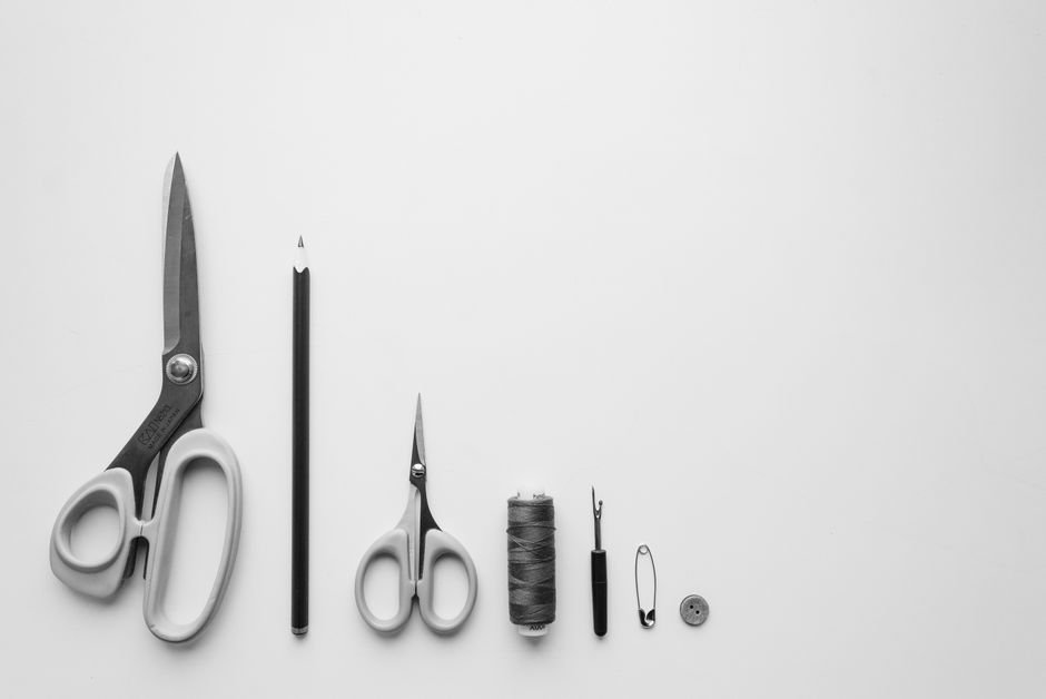 Sewing tools including scissors, thread, and notions laid out in a row
