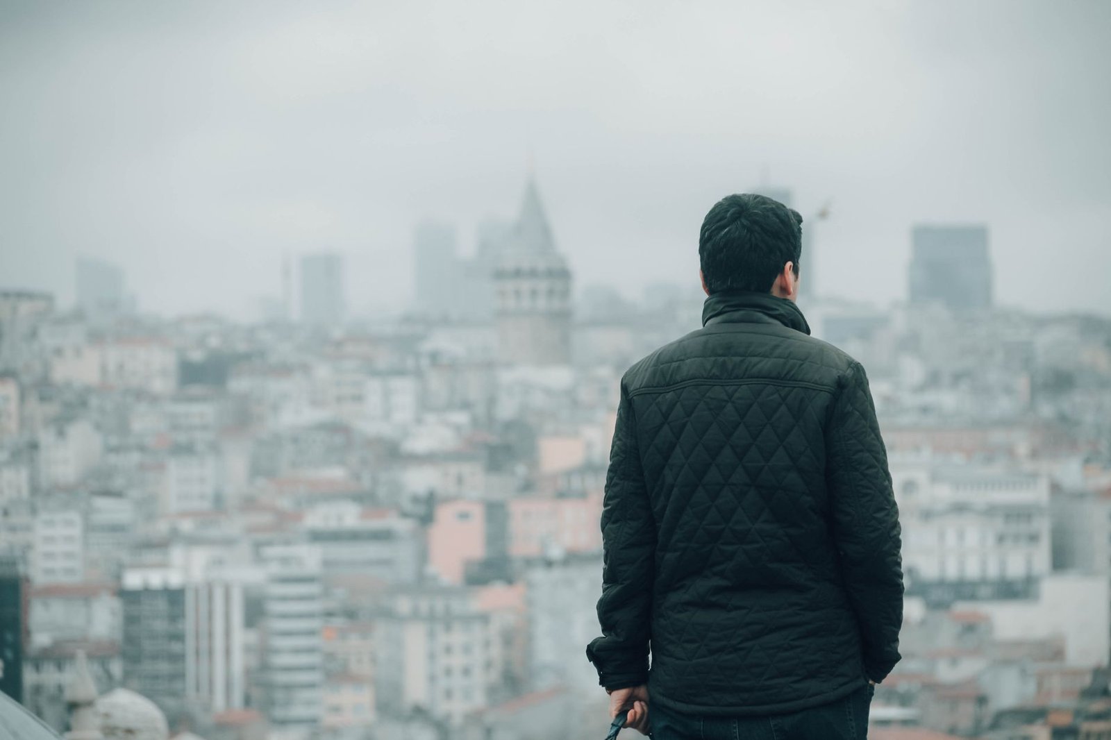 Person seen from behind wearing a diamond-quilted jacket in a city setting
