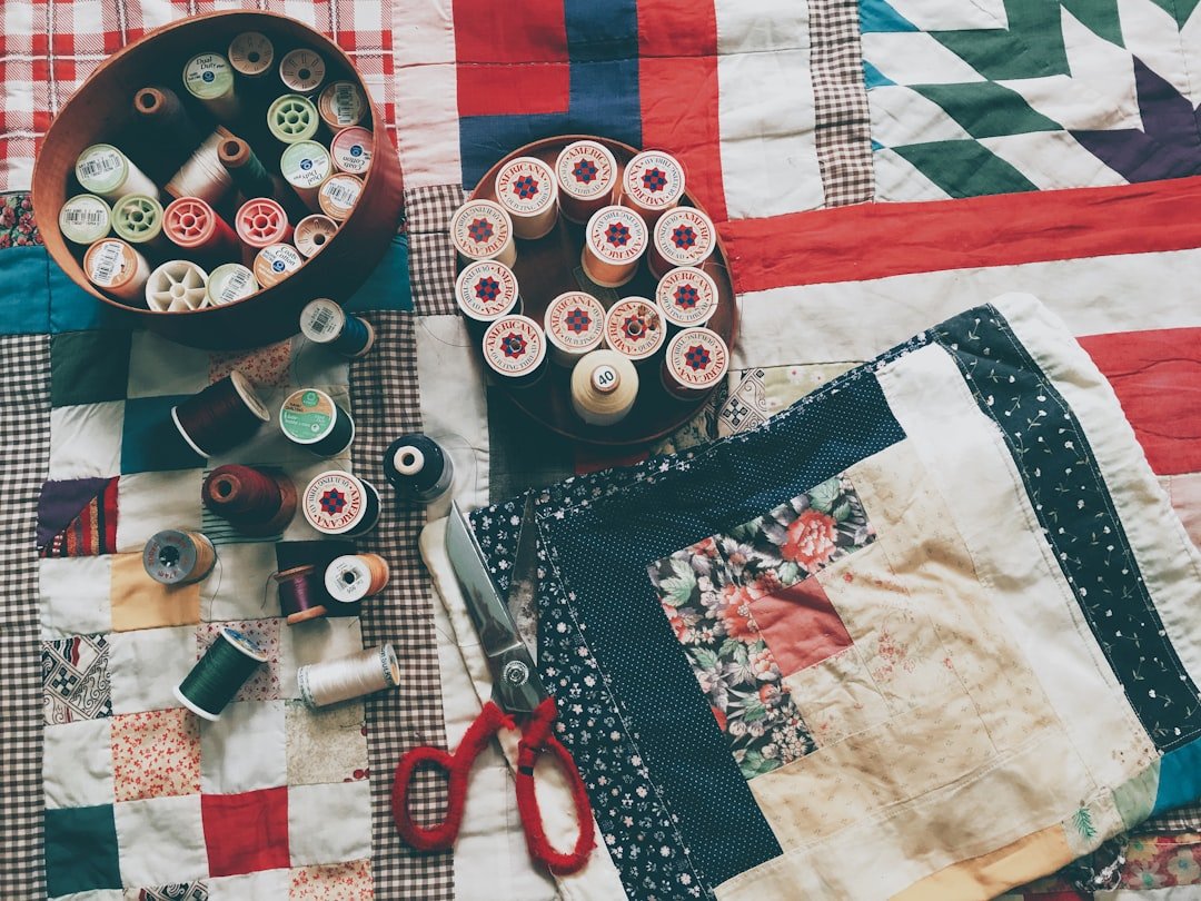 Vintage thread spools arranged on antique patchwork quilts