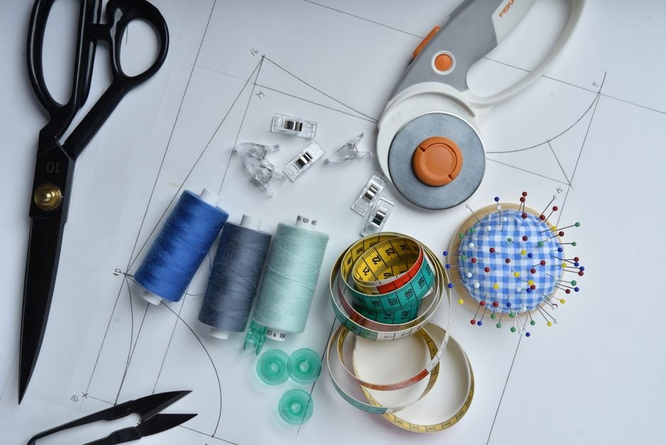 Rotary cutter, thread, and pins arranged on a cutting mat
