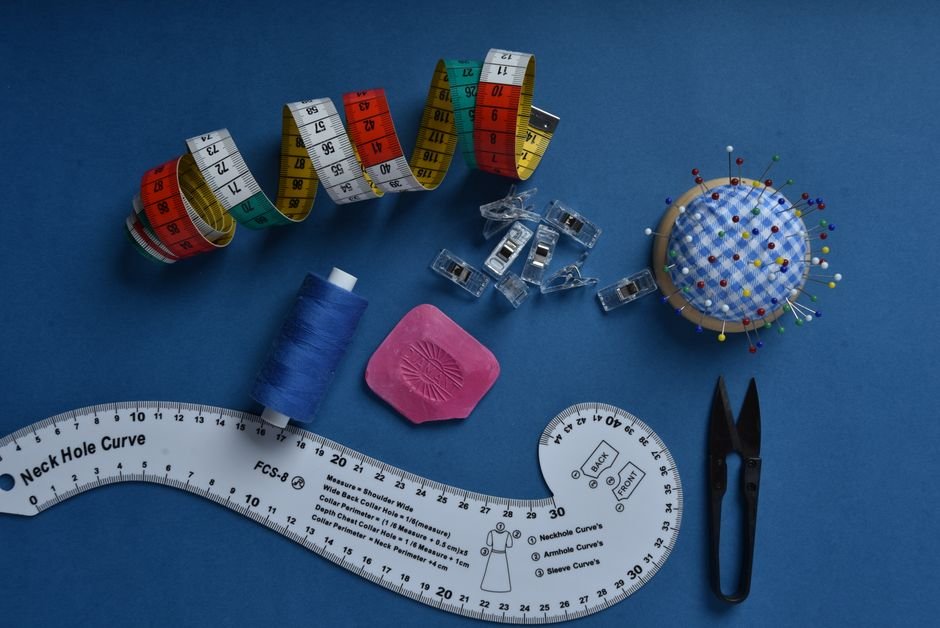 Rotary cutter and sewing notions arranged on a teal quilting cutting mat