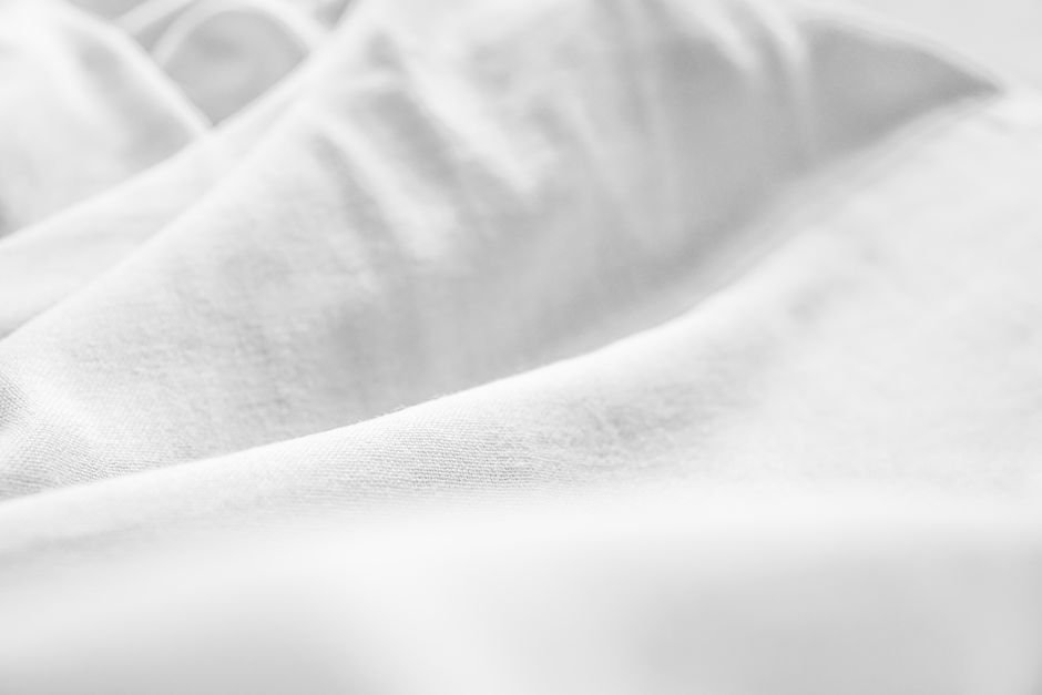 Close-up of smooth white flannel fabric with gentle folds and subtle texture